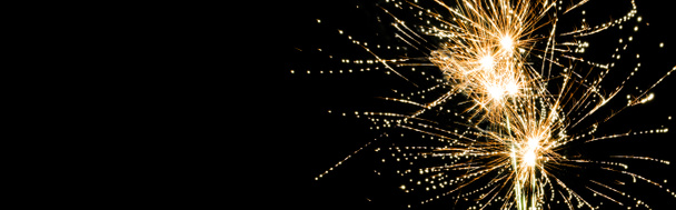 panoramic shot of yellow traditional fireworks in night sky, isolated on black - Photo, Image