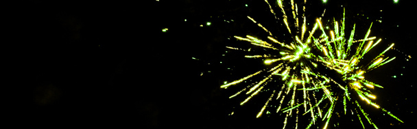 panoramic shot of green festive fireworks on party, isolated on black - Photo, Image