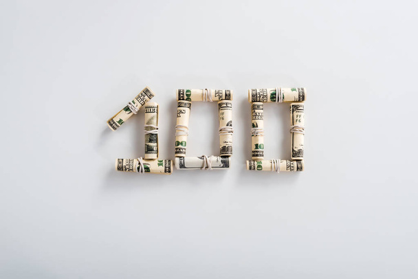 vista superior de billetes de cien dólares en rollos de efectivo en blanco
  - Foto, Imagen