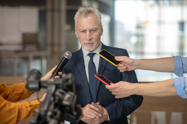 Grey-haired bearded man having a speech at the press conference - Zdjęcie, obraz