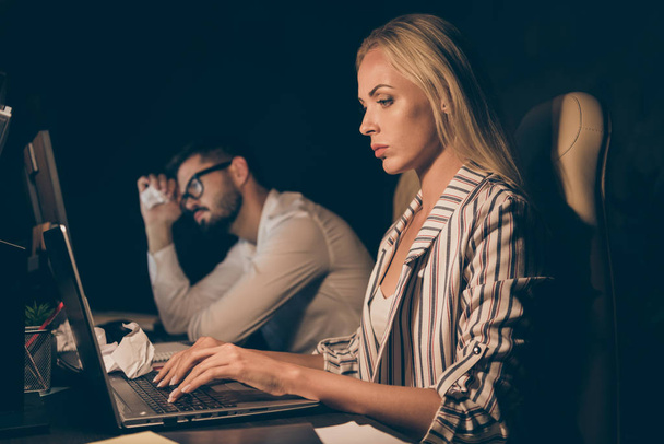 Profile photo of two business partners guy lady sitting chairs table working together late night overwhelmed difficult tasks troubled formalwear lamp light indoors - Foto, Bild