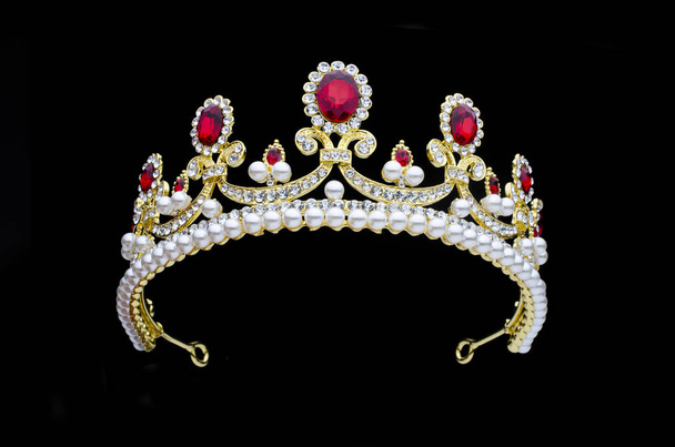 corona dorada con rubíes y perlas sobre fondo negro
 - Foto, imagen