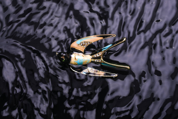 gold enamel brooch swallow bird with diamonds in the water - Photo, Image
