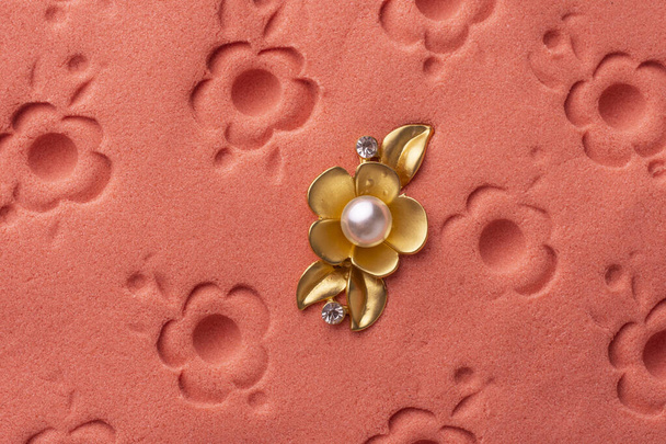 gold brooch flower with a pearl on the pink sand - Photo, Image