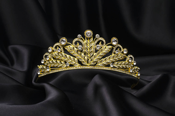 gouden kroon op een zwarte zijde - Foto, afbeelding