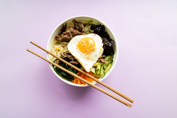 Bibimbap con arroz, carne de res, wakame, huevo, pepino, zanahoria y así
 - Foto, imagen