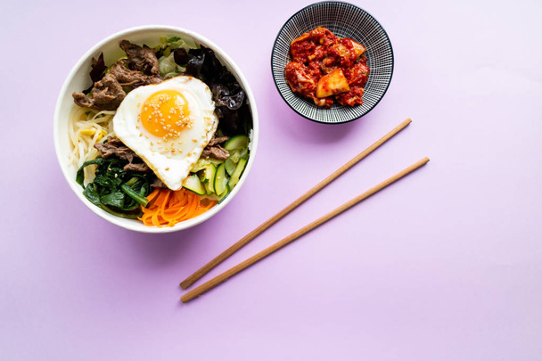 Bi bim bap met rundvlees, wakame, ei en andere groenten en kimch - Foto, afbeelding
