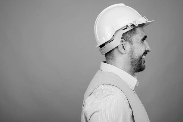 schöner bärtiger persischer Mann Bauarbeiter vor grauem Hintergrund - Foto, Bild