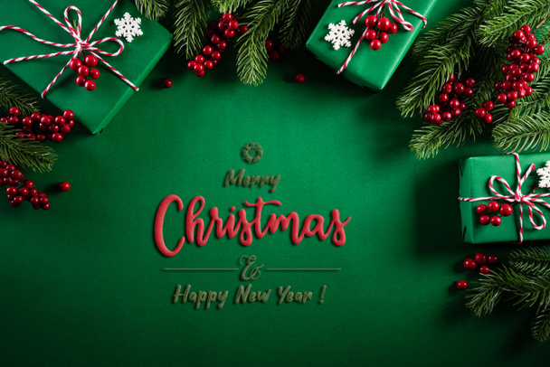 Christmas background concept. Top view of Christmas green gift box with decoration, spruce branches and red berries on green  background. - Photo, Image