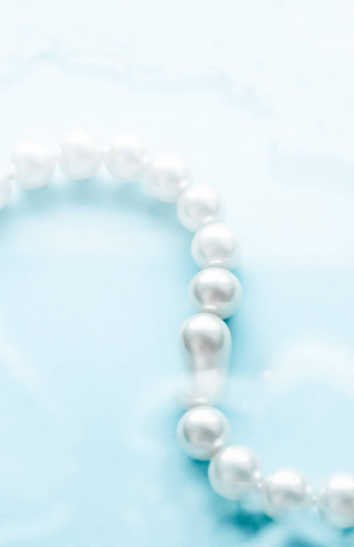 Moda de joyería costera, collar de perlas bajo respaldo de agua azul
 - Foto, imagen