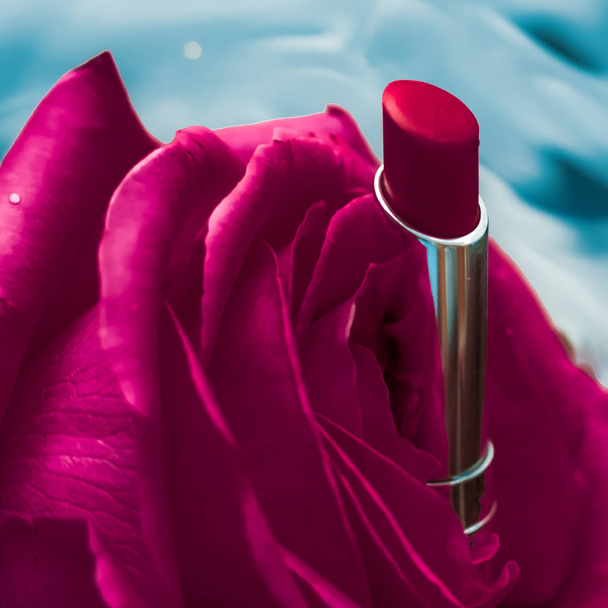 Lápiz labial rosa y flor de rosa sobre fondo líquido, impermeable g
 - Foto, Imagen