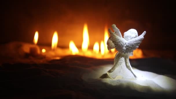 close-up πλάνα της Χριστουγεννιάτικης σύνθεσης με αναμμένα κεριά με αγγελική φιγούρα - Πλάνα, βίντεο