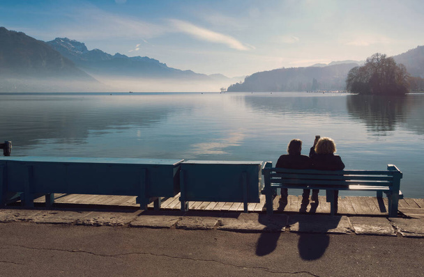 Vista trasera pareja silueta en frente del lago Annecy
 - Foto, Imagen
