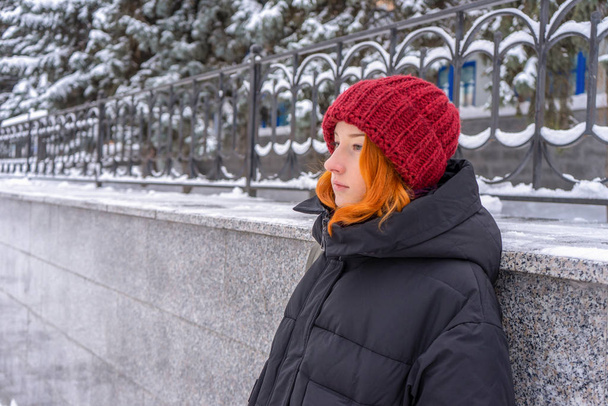 Teen girl wearing casual clothes walking on snow covered city street in winter. Young lady spending weekend in city. Urban vacation, winter holiday, slow life. Fashionable outfit, youth fashion - Fotó, kép