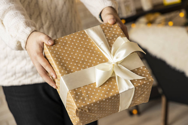 Χριστουγεννιάτικο κουτί δώρου σε πατέρες αρσενικά χέρια χειμερινές διακοπές ζεστό δωμάτιο έννοια μοτίβο ταπετσαρία  - Φωτογραφία, εικόνα