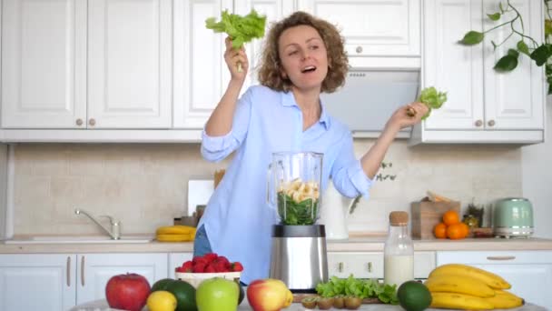 Healthy Happy Lifestyle. Woman Dancing On Kitchen With Salad Preparing Smoothie. - Imágenes, Vídeo