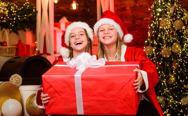 Αυτό που είναι μέσα. Τα παιδιά του Άγιου Βασίλη παρουσιάζουν κουτί. Χειμωνιάτικο κατάστημα με παιδικά ψώνια. Χαρούμενοι φίλοι. Τα χαρούμενα μικρά κορίτσια έχουν χριστουγεννιάτικη διάθεση. Πρωτοχρονιάτικη γιορτή. αδελφές περνούν οικογενειακές διακοπές μαζί - Φωτογραφία, εικόνα
