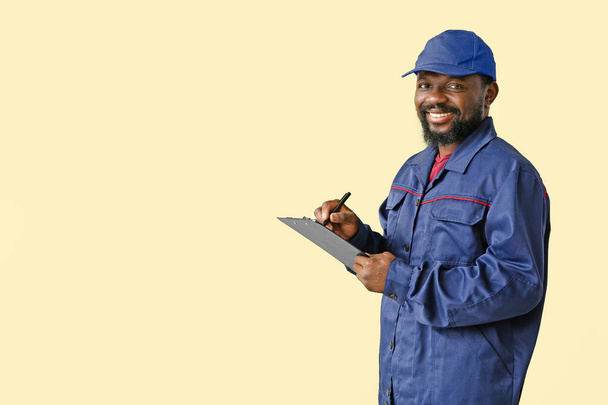 African-American car mechanic on color background - 写真・画像