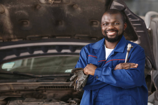 Afro-Amerikaanse monteur werkt in auto service center - Foto, afbeelding