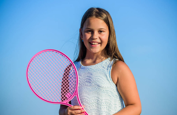Child play tennis blue sky background. Sporty kid. Small girl with pink tennis racket. Summer leisure. Sport game. Playful cheerful kid. Happy childhood. Positive. Emotional baby. Active life - Fotoğraf, Görsel