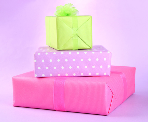 Bright gifts with bows on purple background - Foto, Bild