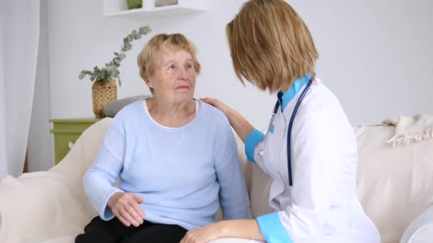 Doctor Visiting Sick Elderly Patient At Home. - Кадри, відео