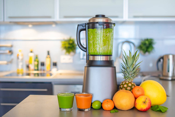 Making green smoothies with blender in home kitchen, healthy eating lifestyle concept - Photo, Image