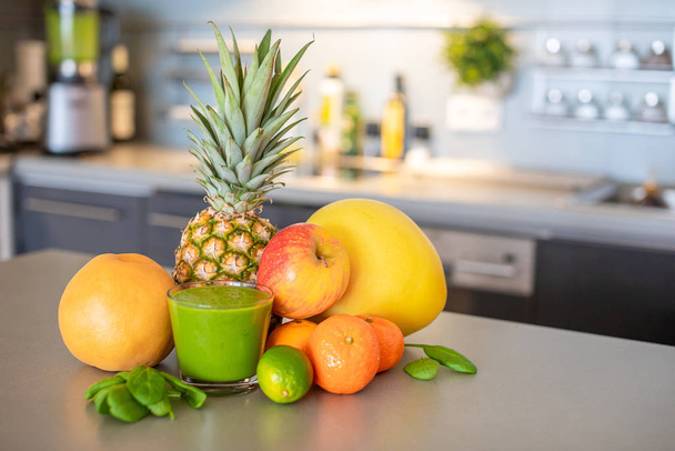 Mutfak arka planında farklı tropikal meyveler ve smoothie, sağlıklı beslenme tarzı konsepti. - Fotoğraf, Görsel