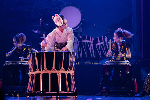 Traditional Japanese performance. Group of actresses drum taiko drums on the stage. - Photo, Image