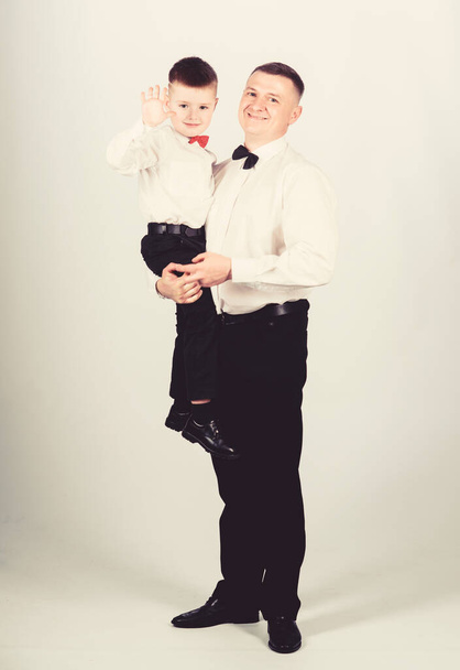 Father carry hug son formal clothes outfit. Grow up gentleman. Gentleman upbringing. Little son following fathers example of noble man. Family holiday. Relations of dad and son. Gentleman upbringing - Foto, afbeelding