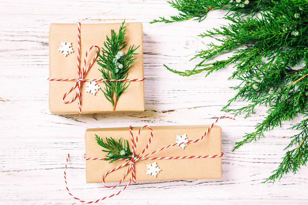 Christmas decorated gift box with fir tree and snowflakes decor on white background top view. Toned - 写真・画像