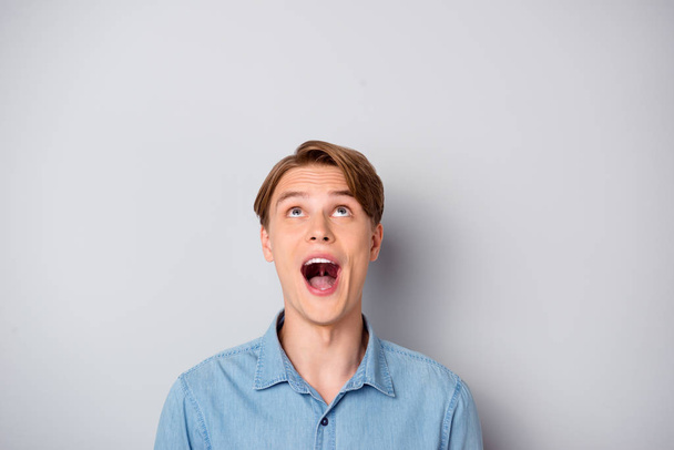 Close up photo of astonished guy stare up copy space incredible bargains impressed wear modern clothing isolated over grey color background - Foto, Bild