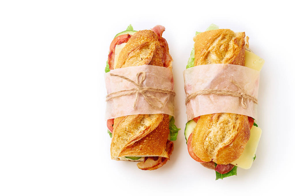 Fresh big baguette sandwiches with bacon and chedder cheese and  lettuce with vegetables isolated on white background - Φωτογραφία, εικόνα