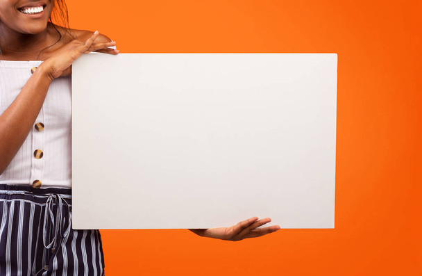 Nerozpoznatelná černošky dívka drží bílý plakát stojící, Studio Shot, oříznuté - Fotografie, Obrázek