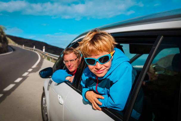 niño pequeño con papá viajar en coche en la carretera en la naturaleza
 - Foto, imagen