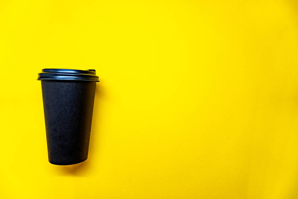 Black coffee cap on yellow background - Fotoğraf, Görsel