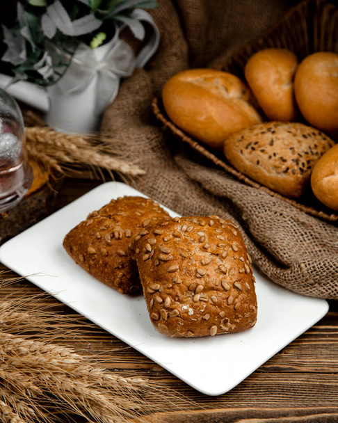 brown bread buns with sunflower seeds on top - Zdjęcie, obraz