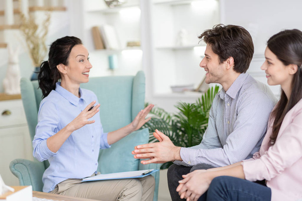 Primer plano de alegre pareja casada escuchando a terapeuta emocional
 - Foto, imagen
