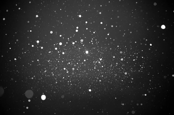 黒で隔離された光の雪 - 写真・画像