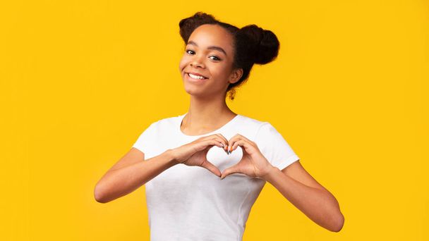 Smiling african american teen showing heart gesture - Fotoğraf, Görsel