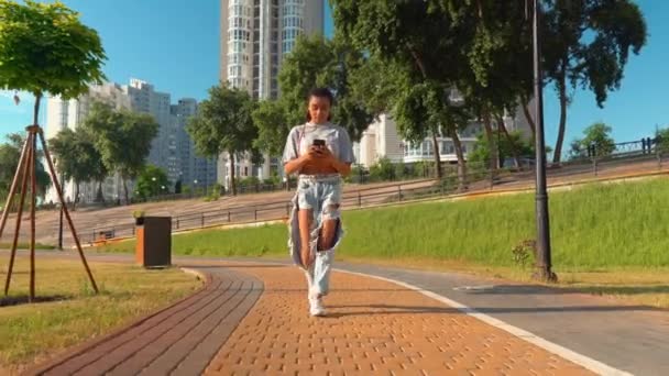 hymyilevä mixed race millennials kävellä ulkona älypuhelimella lue hyviä uutisia
 - Materiaali, video
