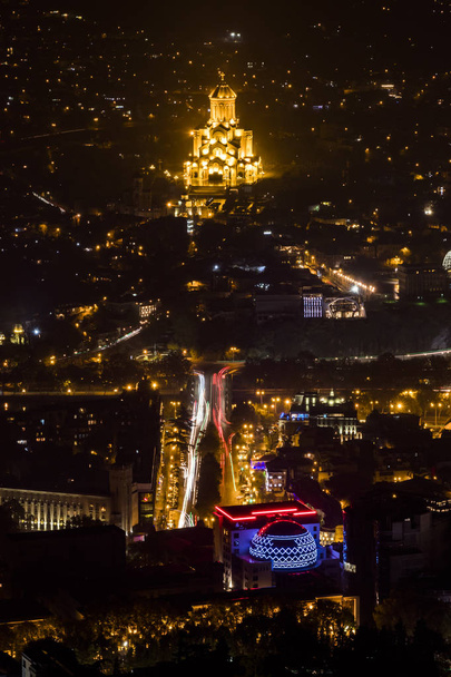 Tbilisi, Georgia A scenic view at night of the city and the illuminated Holy Trinity Cathedral of Tbilisi - Photo, Image