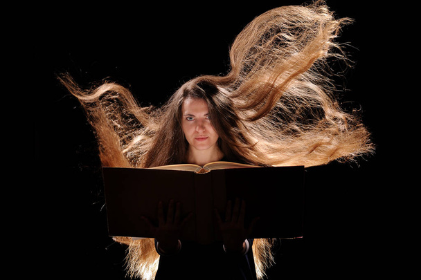 Magic Woman reading a book. black background - Fotó, kép