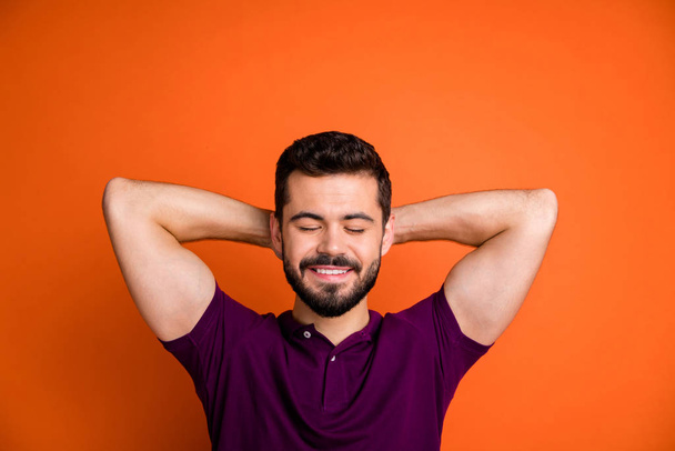 Photo of trendy cheerful positive handsome man holding head with hands lying asleep dreaming of his upcoming successful future with eyes closed isolated vibrant color background - Foto, immagini