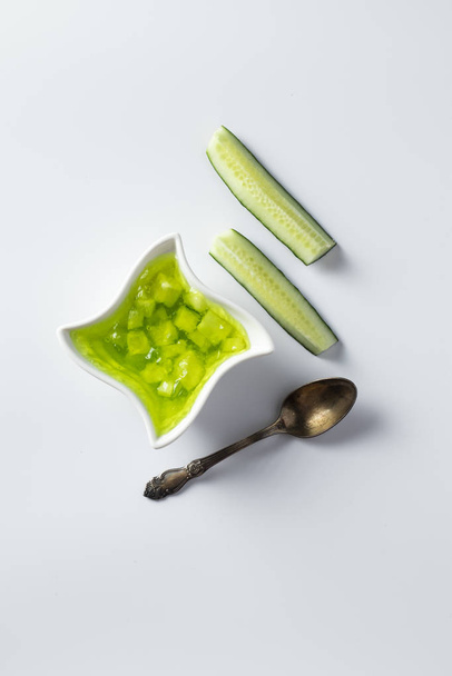 Cucumber jam in a bowl on a bright green background - 写真・画像
