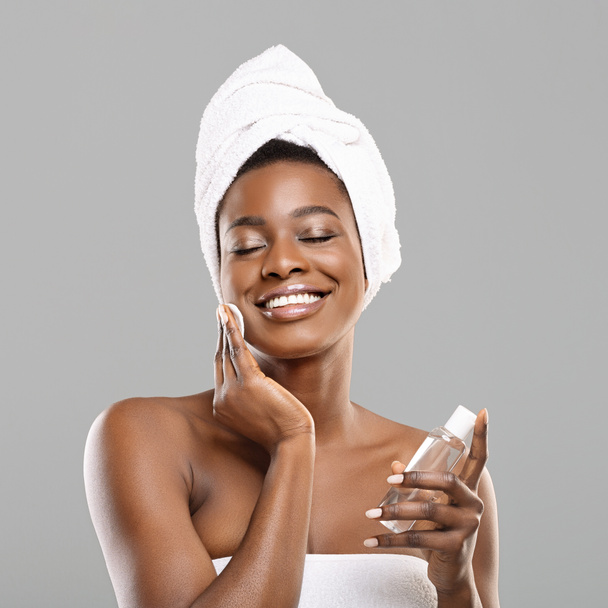 Afrykańska dziewczyna sprzątanie skóry z podkładki bawełniane i toner twarzy po kąpieli - Zdjęcie, obraz