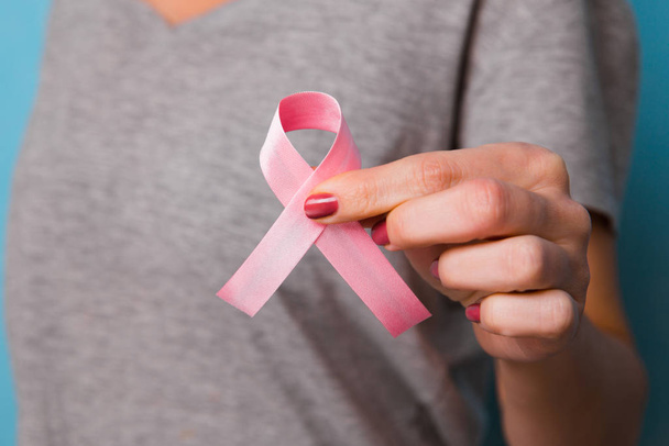 womaen hand holding pink ribbon breast cancer awareness. concept healthcare and - Foto, Imagen