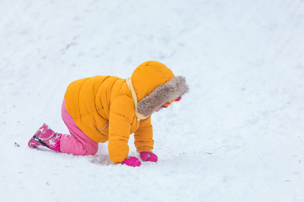 klein meisje spelen buiten in de sneeuw - Foto, afbeelding