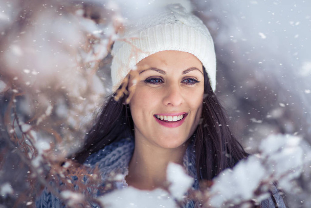 Beautiful, young woman in winterswear broadly smiling. Wintertime - Photo, image