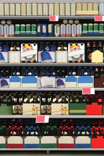 Kartonowy nośnik piwa do szklanych butelek na półce w supermarkecie nadający się m.in. do prezentacji nowych butelek po piwie, opakowań czy wzorów etykiet. - Zdjęcie, obraz